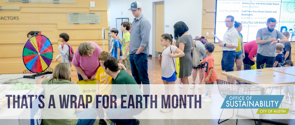 Photo of lots of people and kids lined up to spin a wheel at an outreach table. Overlay text reads "That's a wrap for Earth Month"